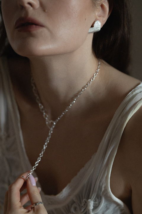 Duże, wyraziste kolczyki serca z dynamicznymi liniami ryflowania. Awangardowe i eleganckie, doskonałe do stylizacji power dressing i minimalistycznych zestawów. Ręcznie wykonane ze srebra 925, pięknie odbijają światło. Idealny walentynkowy prezent. Odkryj biżuterię UMIAR!