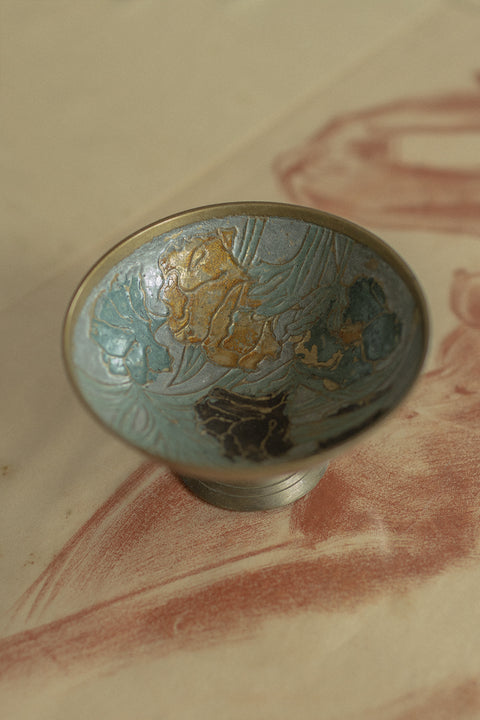 Elegancka mosiężna szkatułka na smukłej nóżce od UMIAR biżuteria, z wieczkiem ozdobionym techniką cloisonné. Idealna do przechowywania drobiazgów i biżuterii, dekorowana secesyjnym, kwiatowym motywem wewnątrz. Perfekcyjny ozdobny element wnętrza, łączący funkcjonalność z estetyką. Dodaj luksusu do swojego domu!