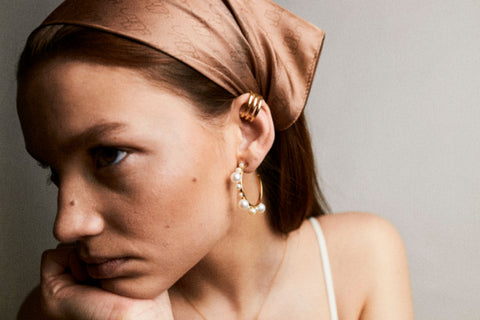 Poznaj eleganckie i wyraziste kolczyki koła z ornamentem z naturalnych pereł różnej wielkości od UMIAR biżuteria. Ich wyjątkowy design sprawia, że stanowią nie tylko ozdobę, ale także wyrazisty element Twojej stylizacji. Noś je samodzielnie lub w zestawie z nakładkami GEMINA. Wykonane ręcznie z białego złota próby 585, łączą wzornictwo z rzemiosłem, inspiracje z kreacją, perły ze szlachetnym srebrem i złotem. Odkryj swój wyjątkowy styl już teraz!