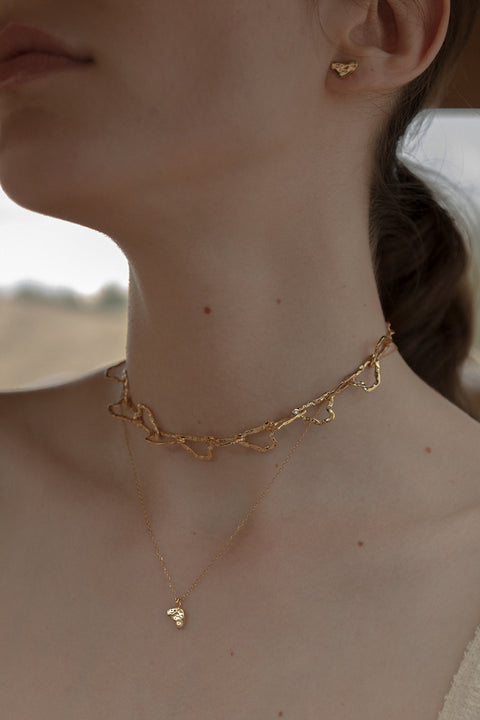 Odkryj unikalny naszyjnik typu choker z kolekcji UMIAR biżuteria. Wykonany ręcznie ze szlachetnych materiałów, ten wielowymiarowy naszyjnik z ogniwami, inspirowany konturami warstwic Monte Solaro, wyróżnia się niezwykłą strukturą i designem. Idealnie podkreśla dekolt i dzięki przedłużce umożliwia regulację długości, co gwarantuje komfort noszenia i dopasowanie do różnych stylizacji.